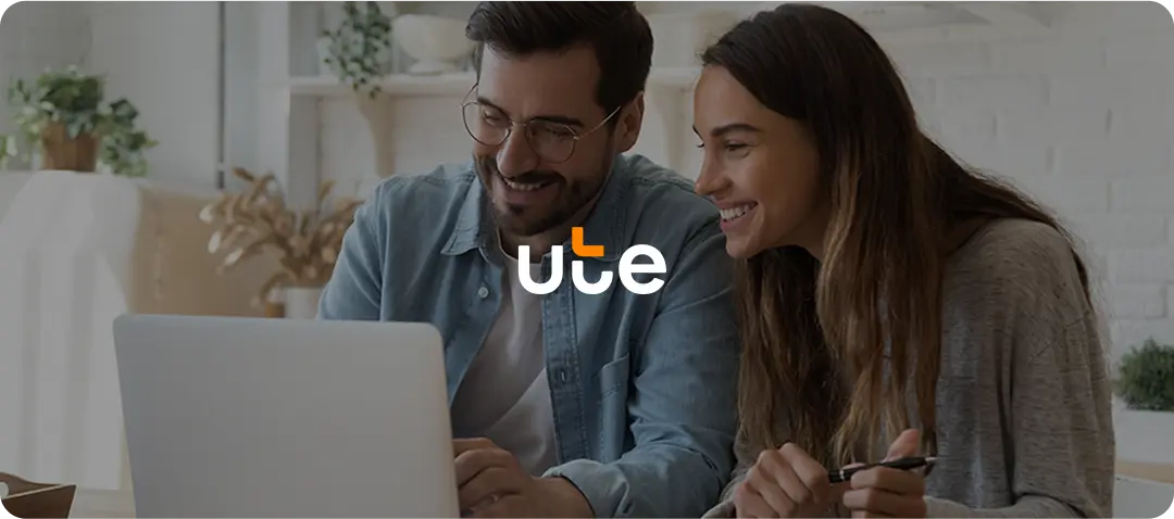 Couple smiling while using laptop with UTE logo overlay